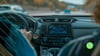 Car dashboard while driver is driving car with his hands on the wheel. 