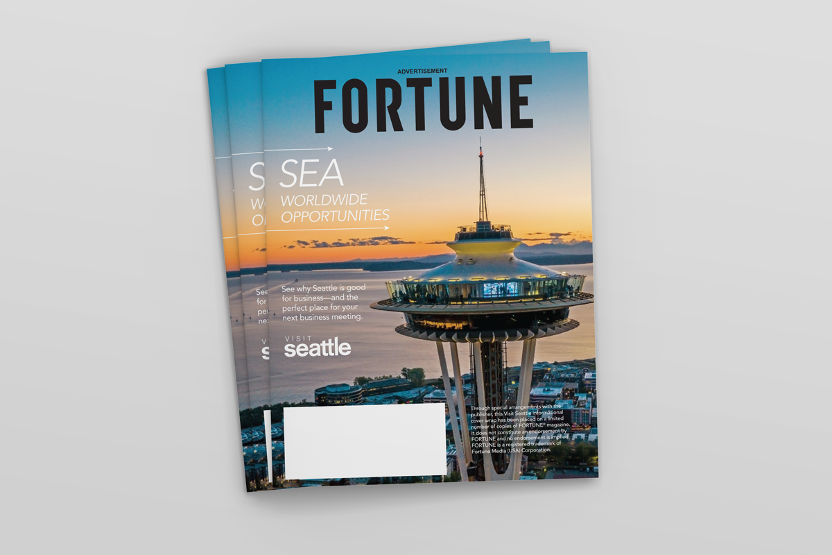 Image of several Visit Seattle Cover Wrap issues, stacked loosely on top of each other. The space needle is visible in the foreground and the headline reads "Sea Worldwide Opportunities"