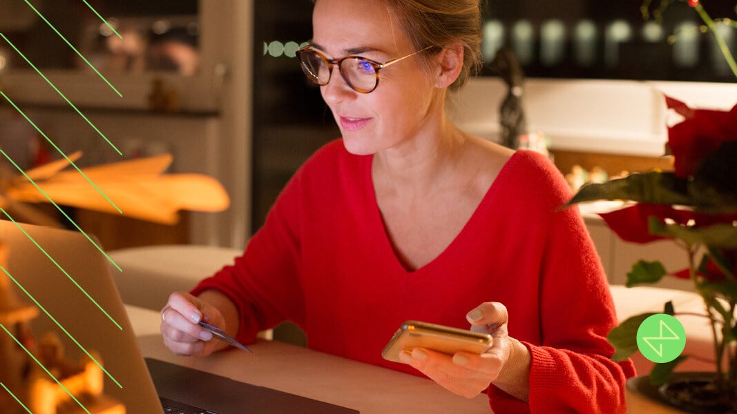 woman with round brown glasses shopping online in a red sweater